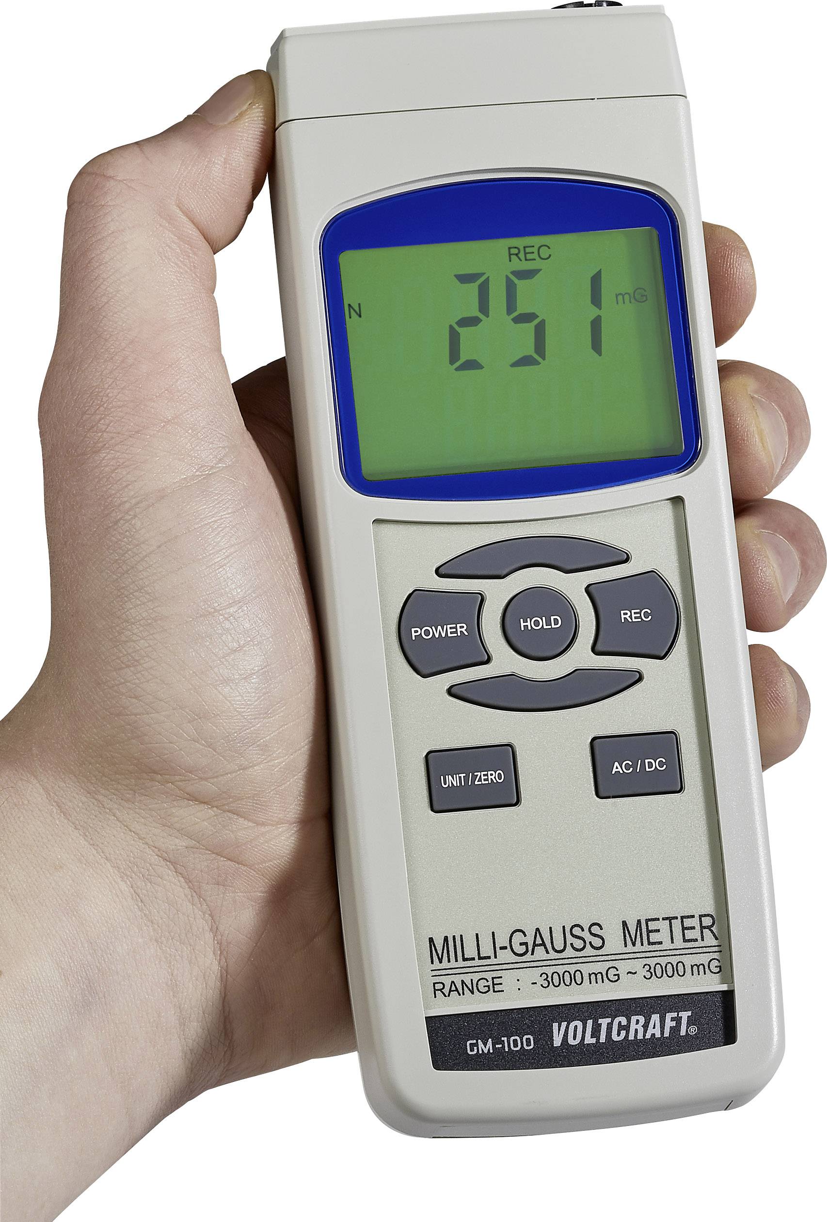 Eine Hand hält ein Milligauss-Messgerät von Voltcraft, zeigt 251 mG auf dem Display an. Tasten: Power, Hold, Rec, Unit/Zero, AC/DC.