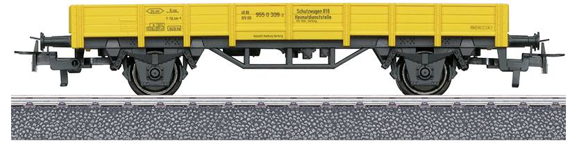 Ein Modelleisenbahn-Flachwagen mit einem hellgelben Aufbau und schwarzem Untergestell, ausgestellt auf einem Gleisabschnitt mit Kiesdetails.
