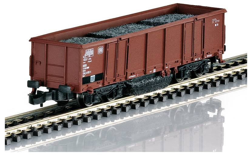 Ein Modellzug-Güterwagen gefüllt mit kohleähnlichem Material sitzt auf einem Gleis und zeigt detailliertes Design und rote Außenfarbe.