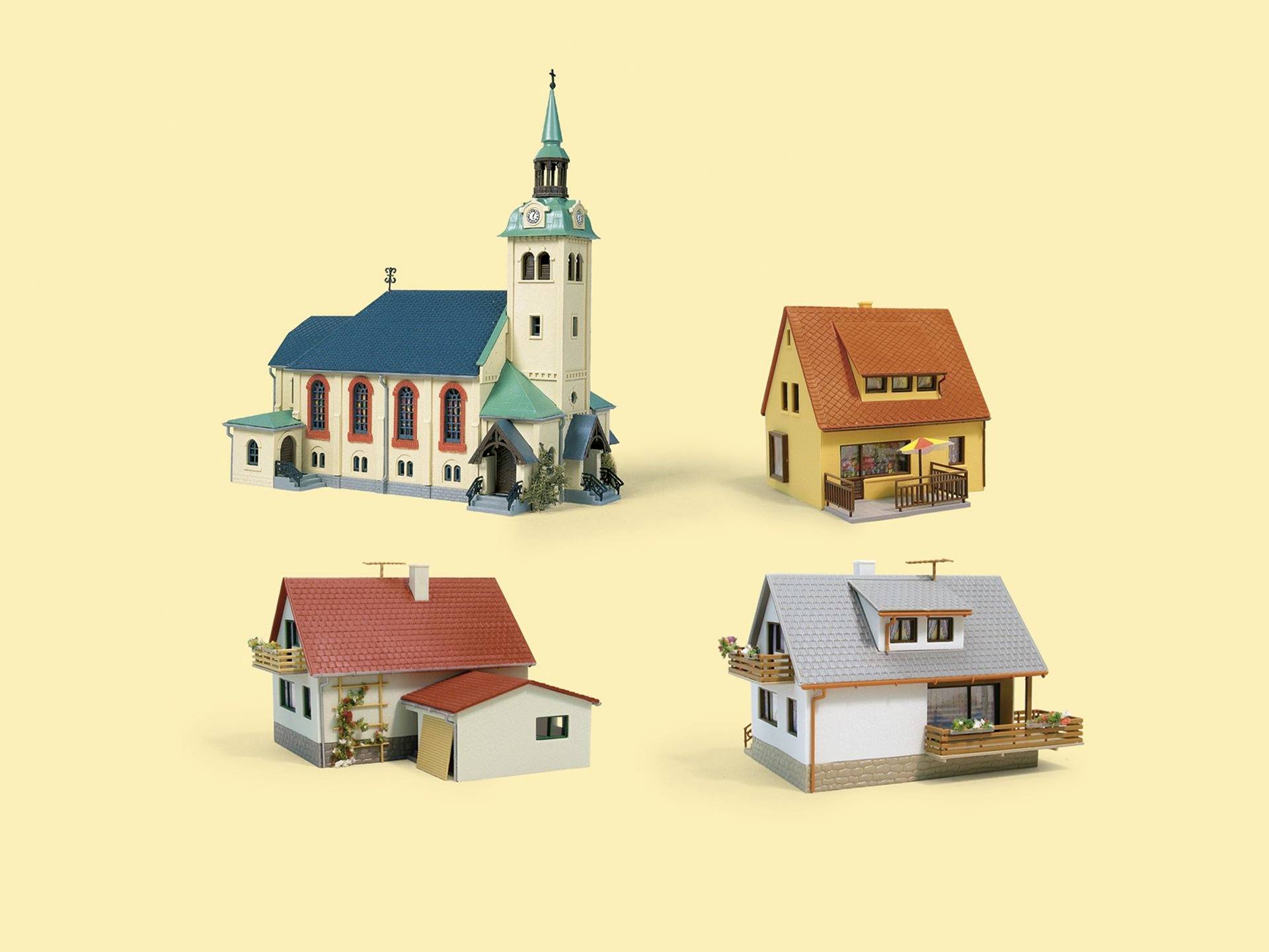 Vier Miniaturhäuser und eine Kirche mit türkisfarbenem Dach auf einfachem Hintergrund, das architektonische Vielfalt hervorhebt.