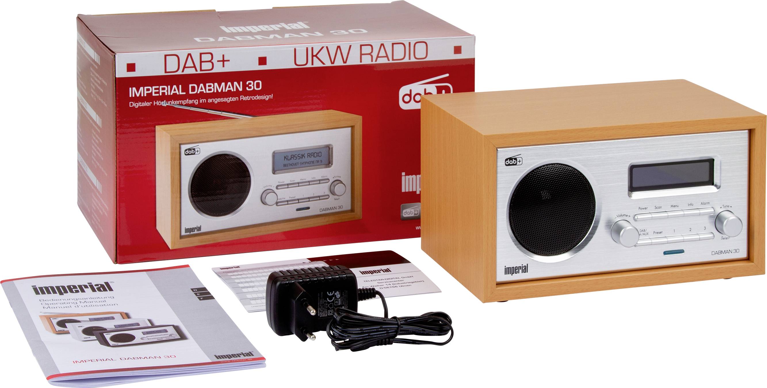 Radio im Retro-Design mit Lautstärkeregler und Display, daneben ein Karton mit demselben Radio abgebildet, Broschüre und Netzteil.