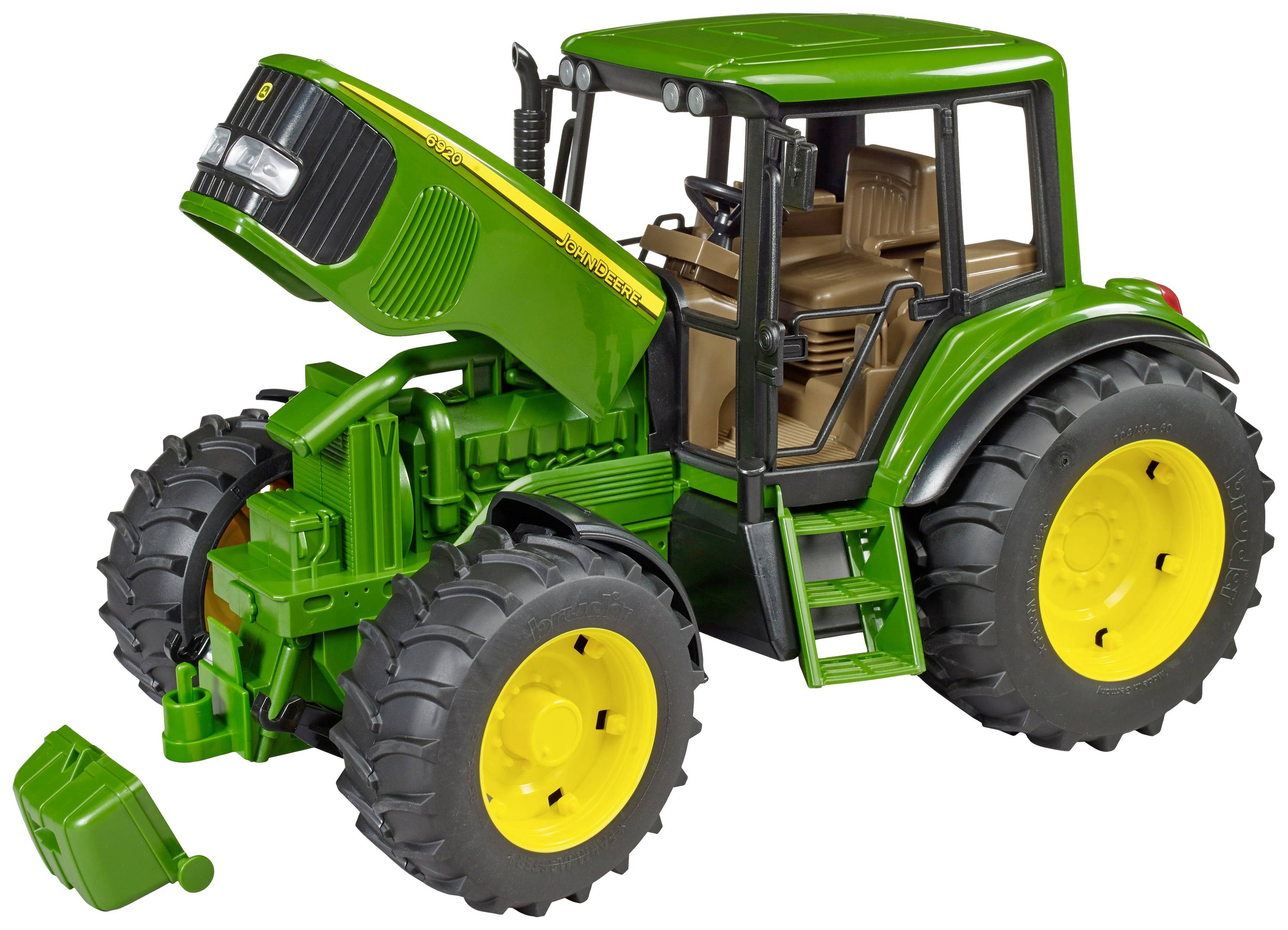 Ein grüner Spielzeugtraktor mit gelben Rädern hat die Motorhaube geöffnet. Ein abnehmbarer Kanister liegt daneben auf dem Boden.