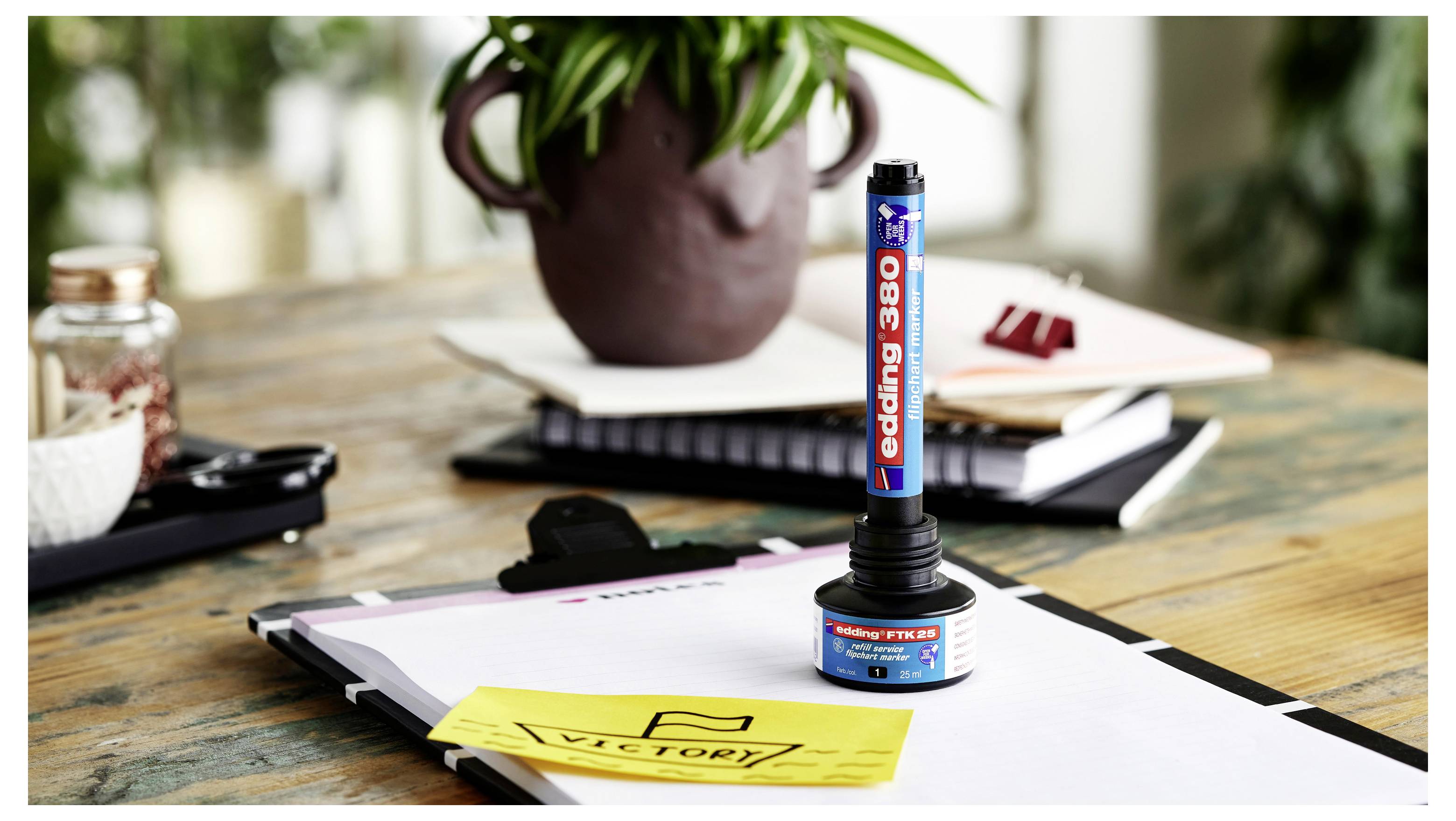 Ein blauer Stempel „Reding 8B" steht auf Dokumenten mit einem gelben „VICTORY!"-Notiz auf einem Schreibtisch, was Genehmigung oder Bestätigung andeutet.