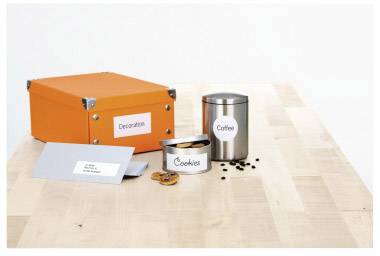 Eine orange Box mit der Aufschrift 'Decoration', eine Metalldose 'Coffee', eine offene Keksdose 'Cookies', und ein grauer Umschlag.