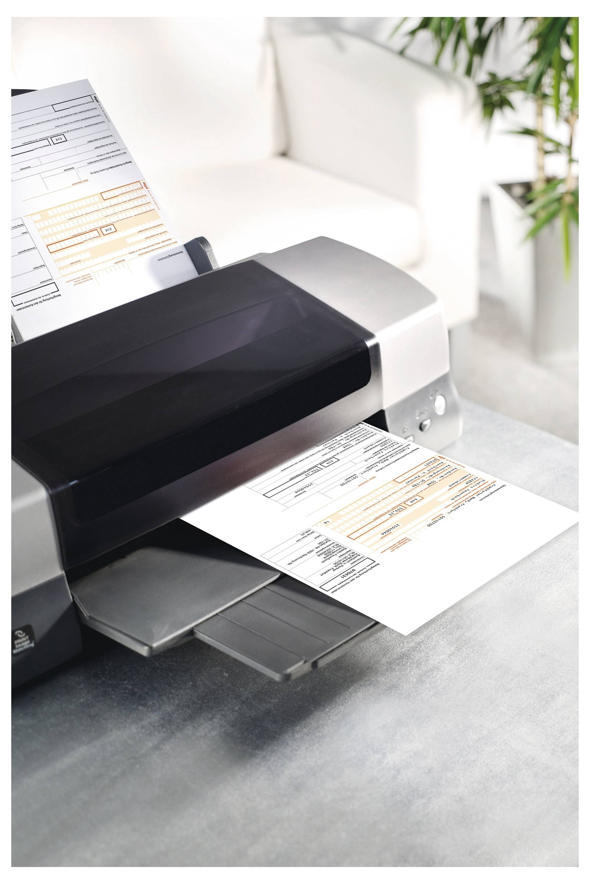 Drucker scannt und druckt ein Formular auf einem Schreibtisch, wobei ein Blatt hineingeführt wird und ein anderes herauskommt.