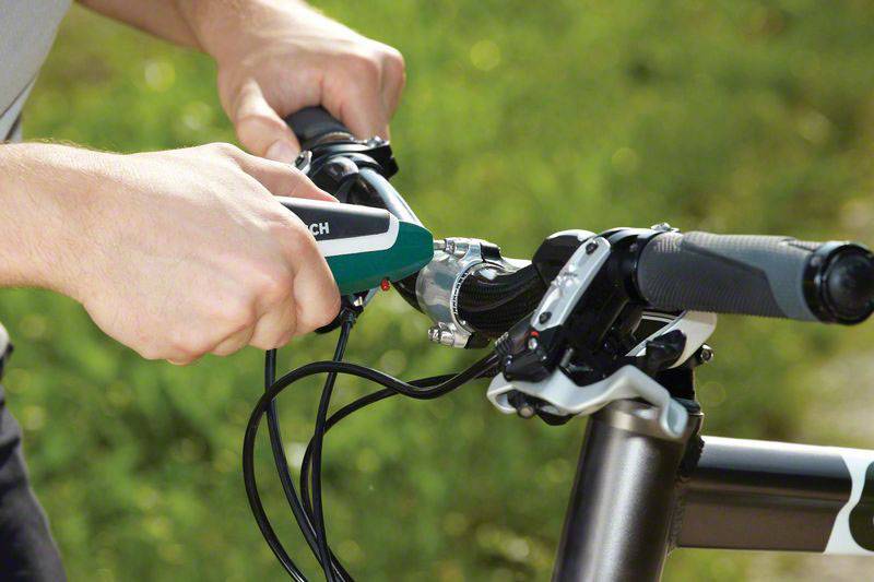 Eine Person befestigt einen neuen Fahrradgriff am Lenker eines Fahrrads, während sie den Fahrradmechanismus überprüft.