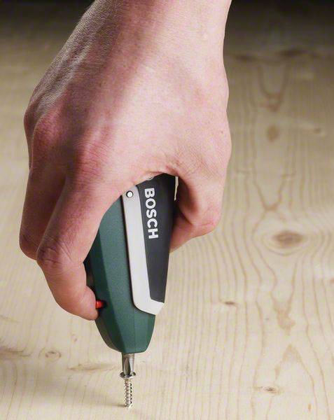 Eine Hand hält einen elektrischen Schraubendreher einer bekannten Marke und zieht eine Schraube in eine Holzplatte ein.
