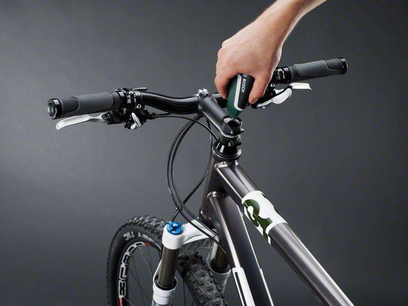 Eine Hand zeigt die Justierung eines Fahrradlenkers mit einem Innensechskantschlüssel. Der Lenker ist an einem Mountainbike montiert.