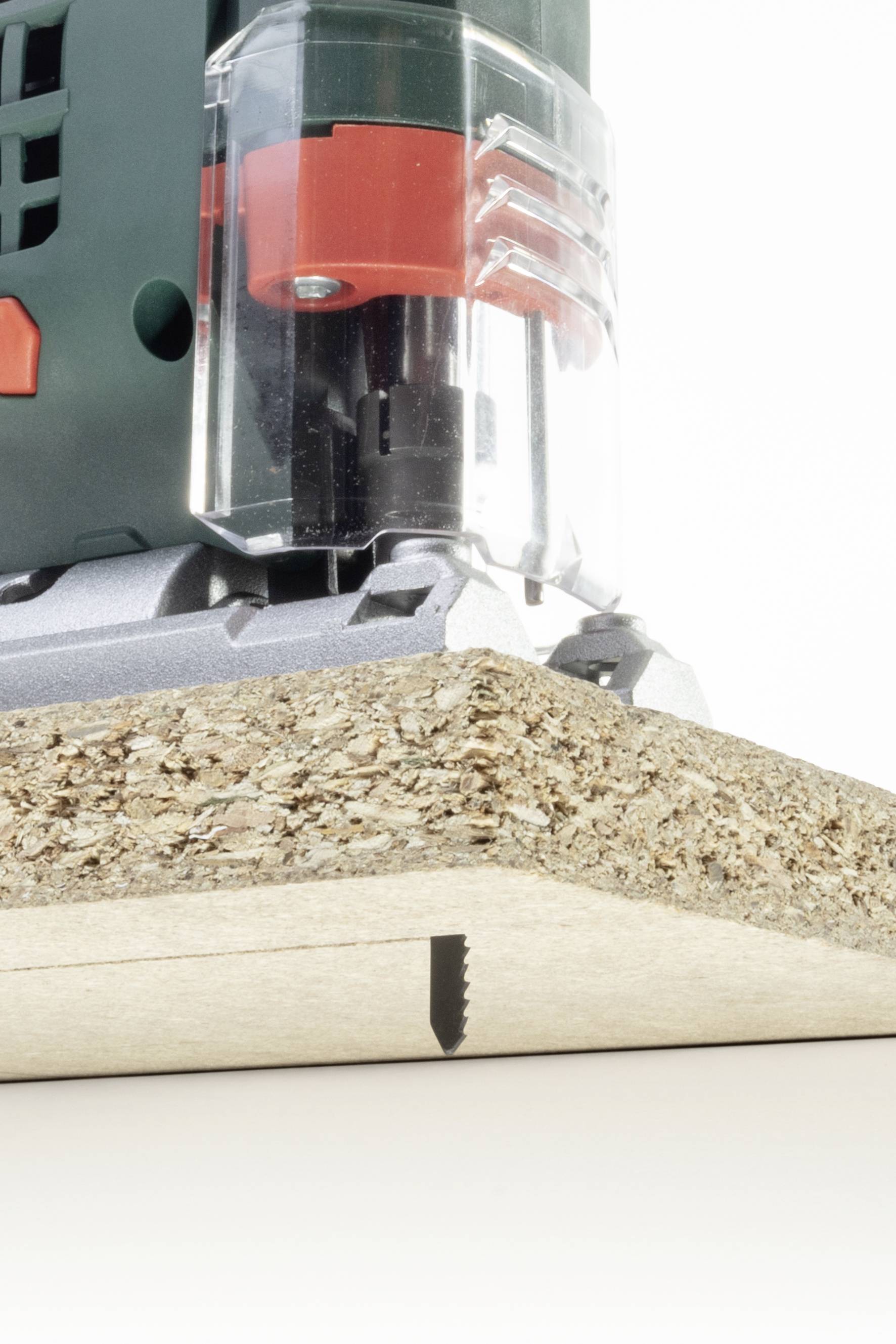 Nahaufnahme eines elektrischen Werkzeugs beim Fräsen einer Spanplatte. Ein präziser Schnitt ist sichtbar.