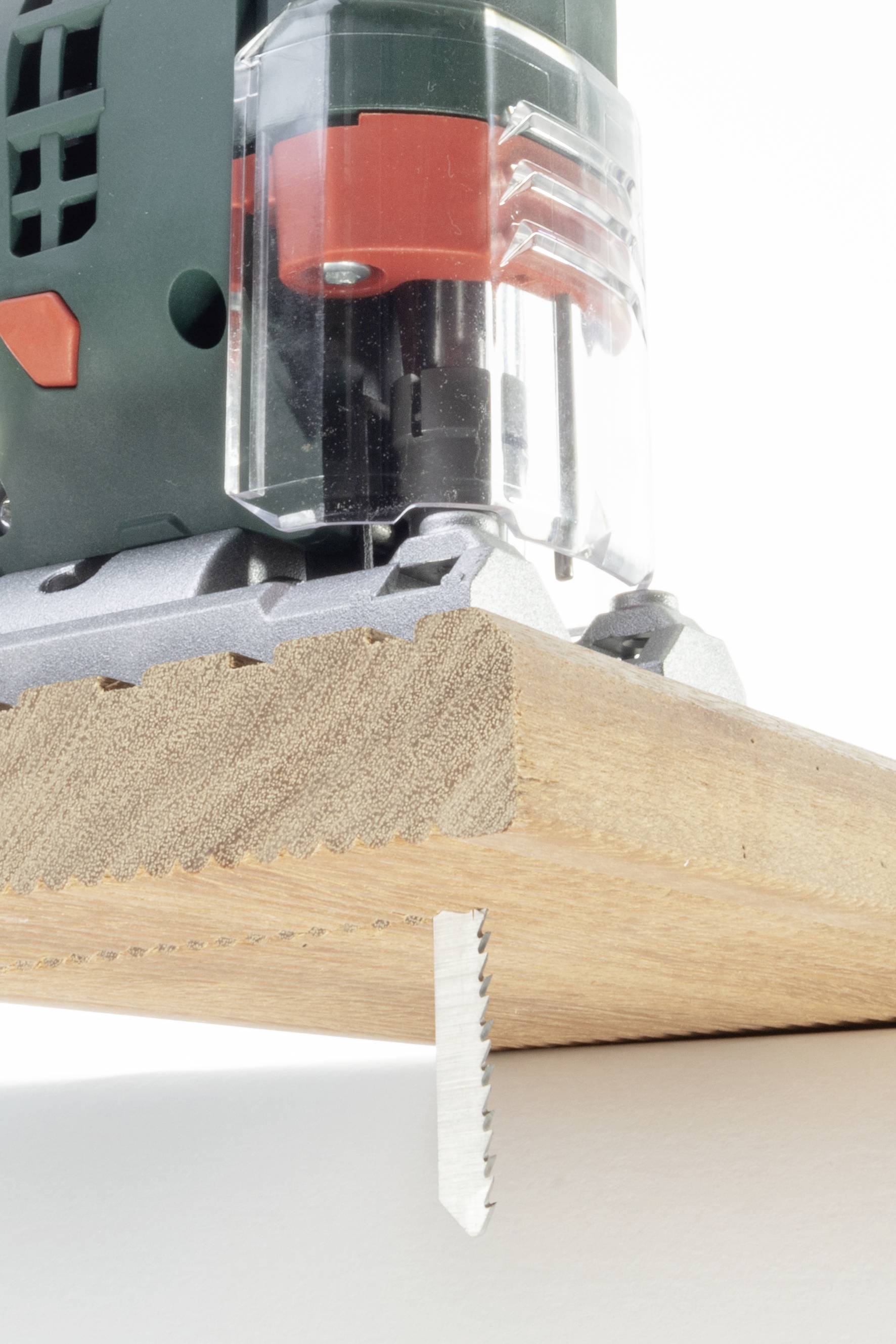 Akkustichsäge schneidet durch ein Holzbrett. Nahaufnahme zeigt die Sägeblätter während des Schneidprozesses.