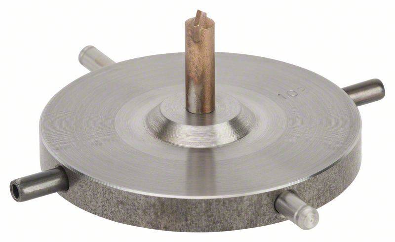 Rundes Metallteil mit vertikalem Mittelstift und vier horizontalen Anschlüssen am Rand, wahrscheinlich ein technisches Bauteil.