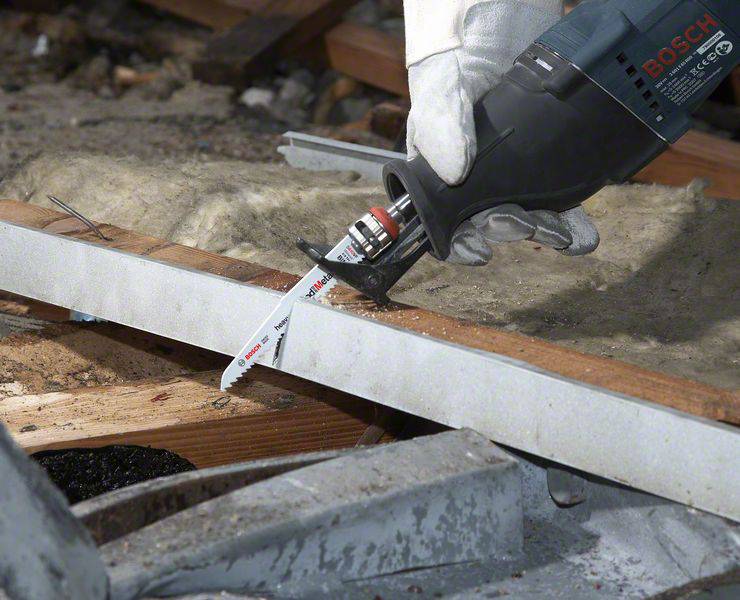 Eine Hand mit Schutzhandschuh hält eine elektrische Säbelsäge von Bosch, die dabei ist, ein Metallstück zu durchschneiden.