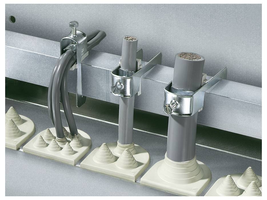 Kabeldurchführungen in einer Metallvorrichtung; linke Seite mit drei dünnen Kabeln, rechte Seite zwei dickere Kabel, alle mit Schellen befestigt.