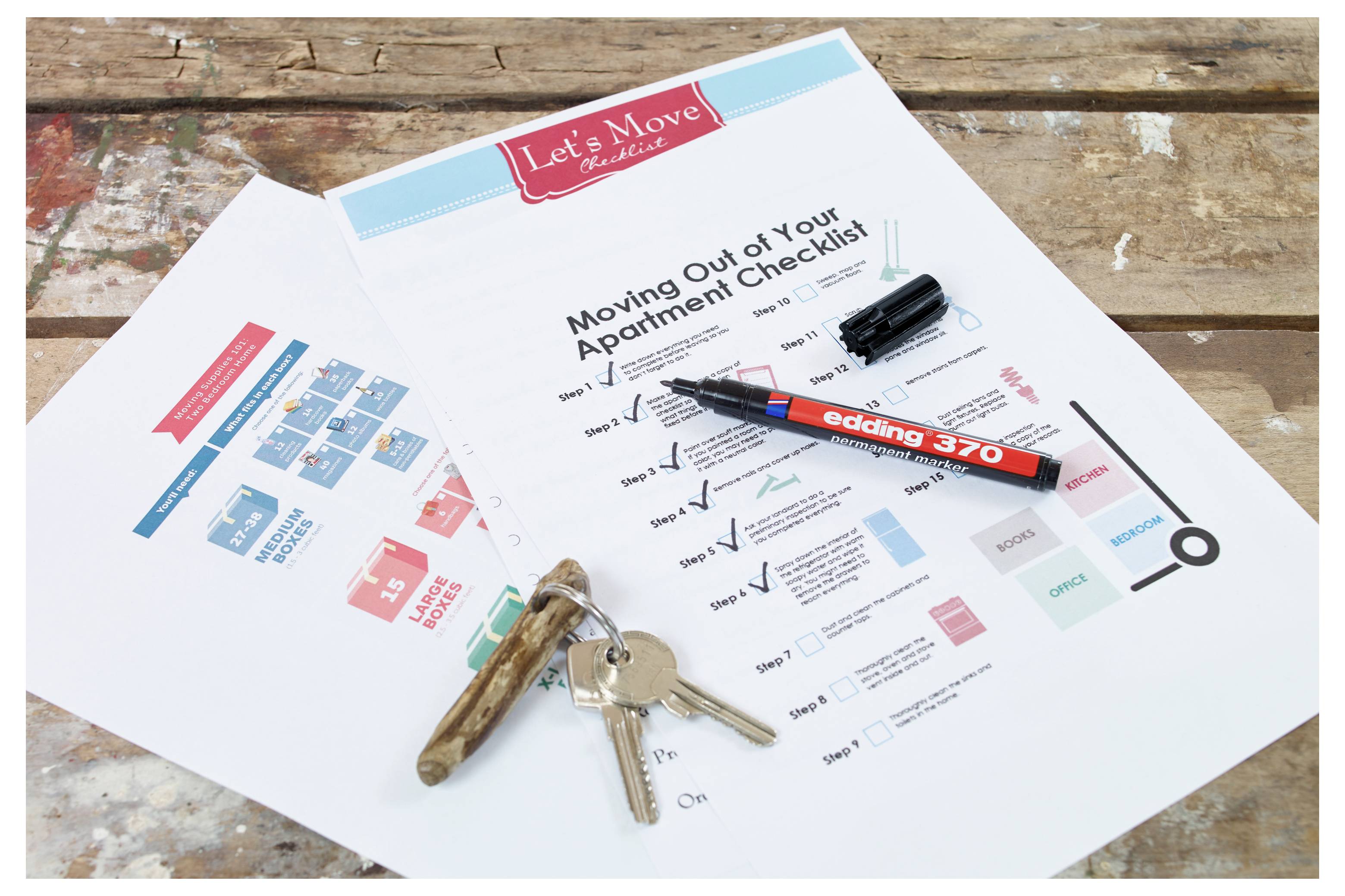 Checkliste zum Ausziehen aus der Wohnung auf einem Holztisch, mit einem Stift, Schlüsseln und einer kleinen Karte, die auf der Seite eingeklebt ist.