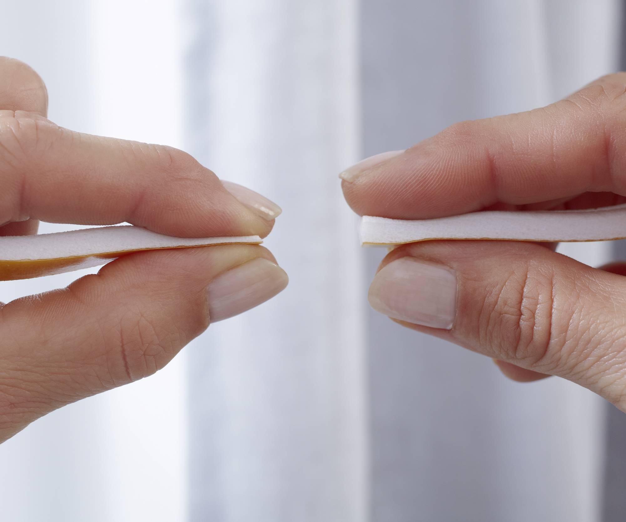 Hände verwenden eine Nagelfeile, um Nägel zu pflegen.