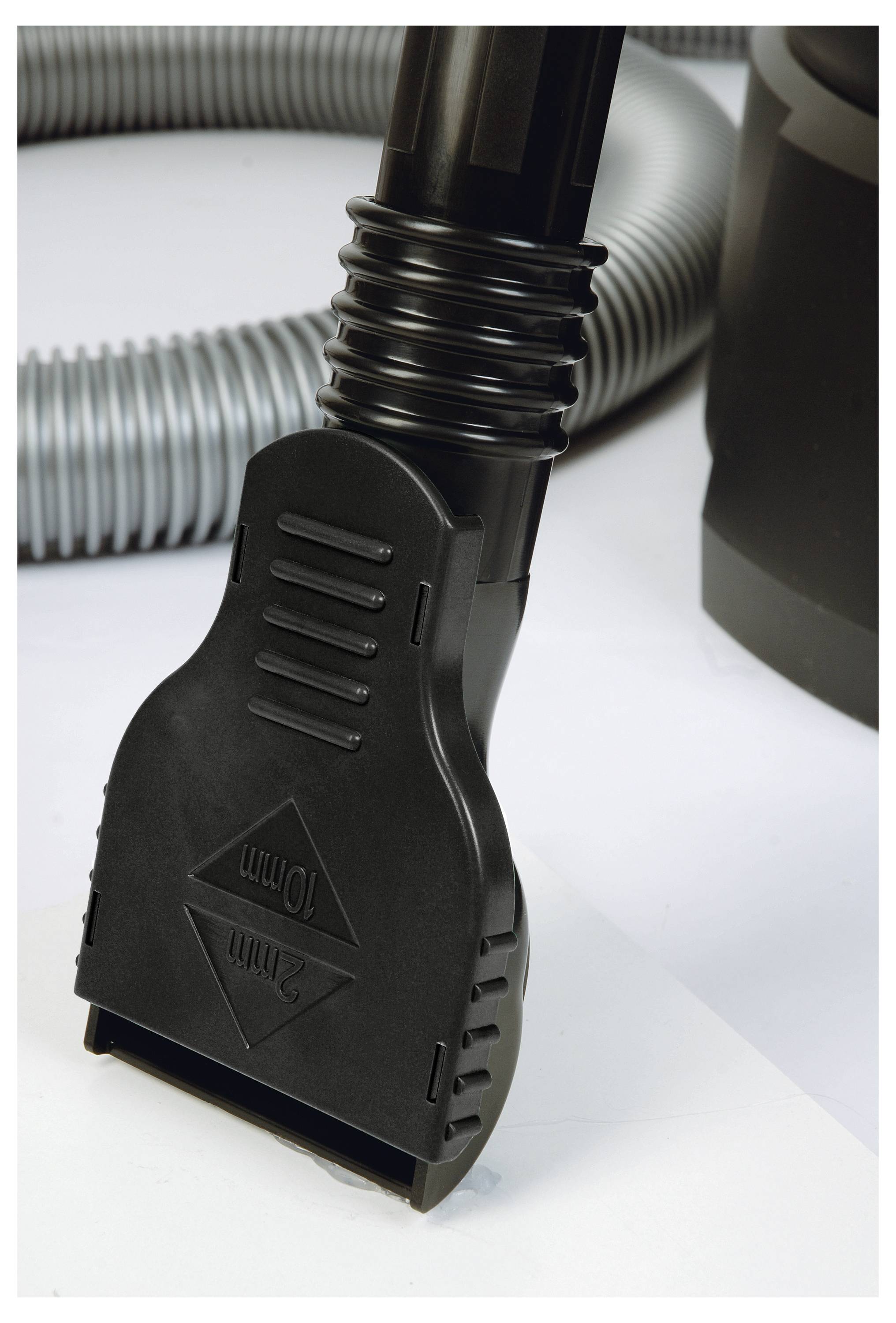 Eine Nahaufnahme eines Staubsaugerschlauchs mit einem schwarzen Kunststoffaufsatz, auf dem '10mm' vor einem hellen Hintergrund zu lesen ist.