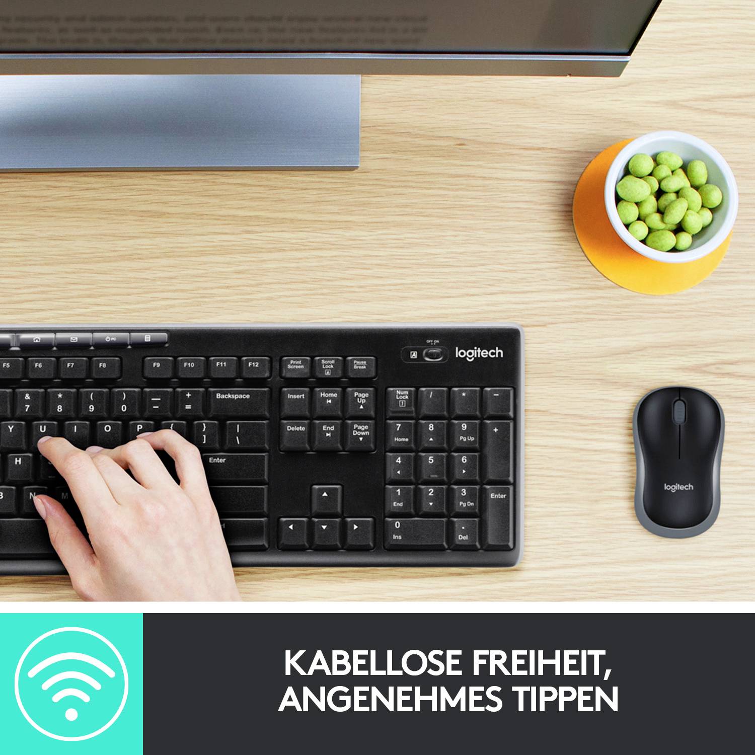 'Kabellose Freiheit, angenehmes Tippen'. Hand tippt auf kabelloser Tastatur neben Maus und Snackschale auf Schreibtisch.