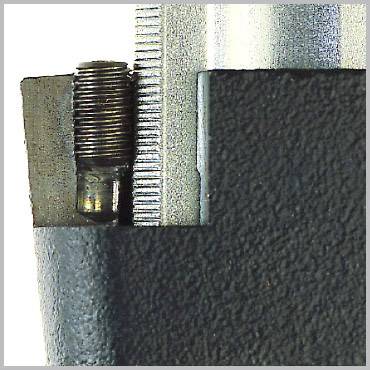Nahaufnahme eines metallischen Bauteils mit Schraube und geriffelter Oberfläche.