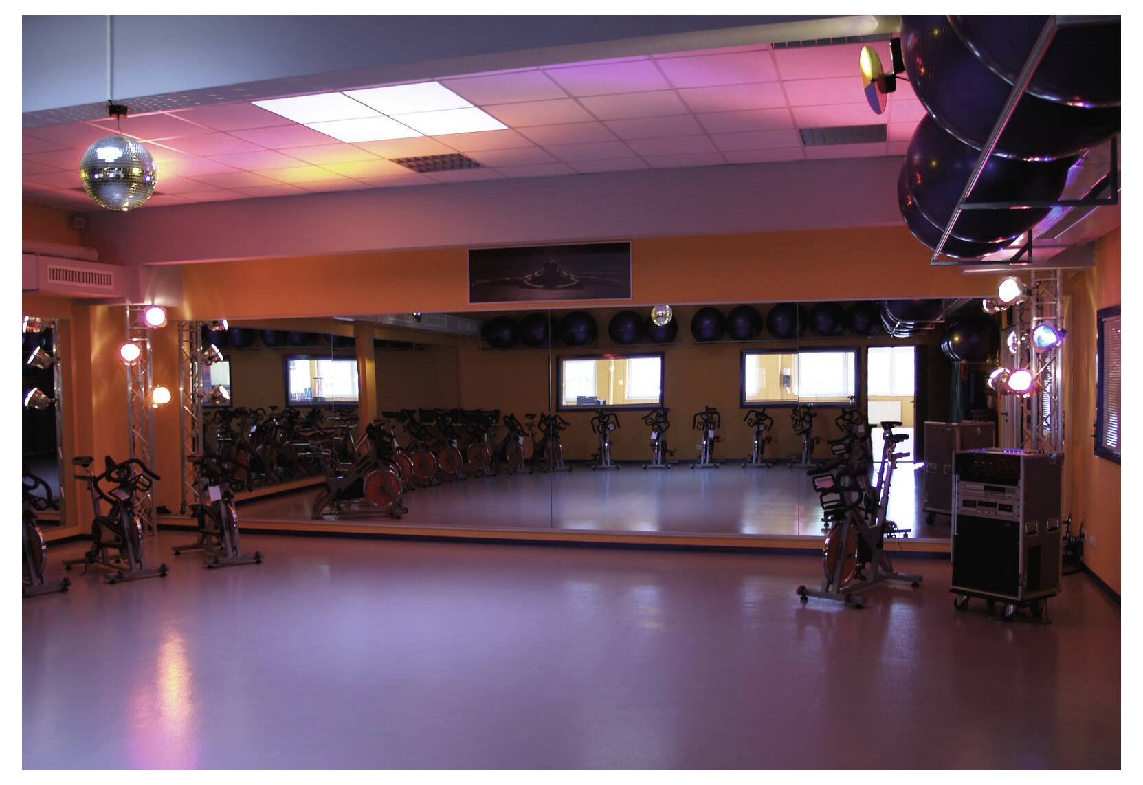 Eine Diskokugel, die von einer Decke in einem schwach beleuchteten Raum mit warmem rotoranger Licht hängt.