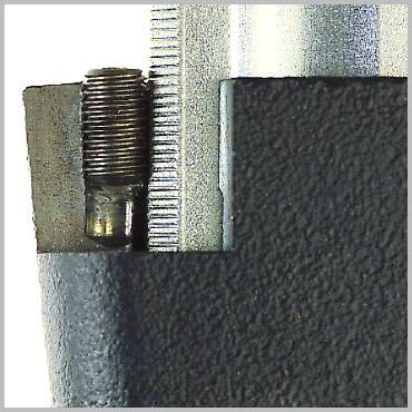 Nahaufnahme einer Metallschraube, die in eine Nut eingreift, neben einem silbernen zylindrischen Objektenteil. Fokus auf Präzision.