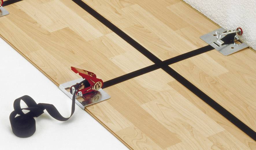Holzboden mit Spannsystem: Spanngurte verbinden Bretter, um sie sicher an der Wand zu befestigen. Geeignet für Bodeninstallationen.