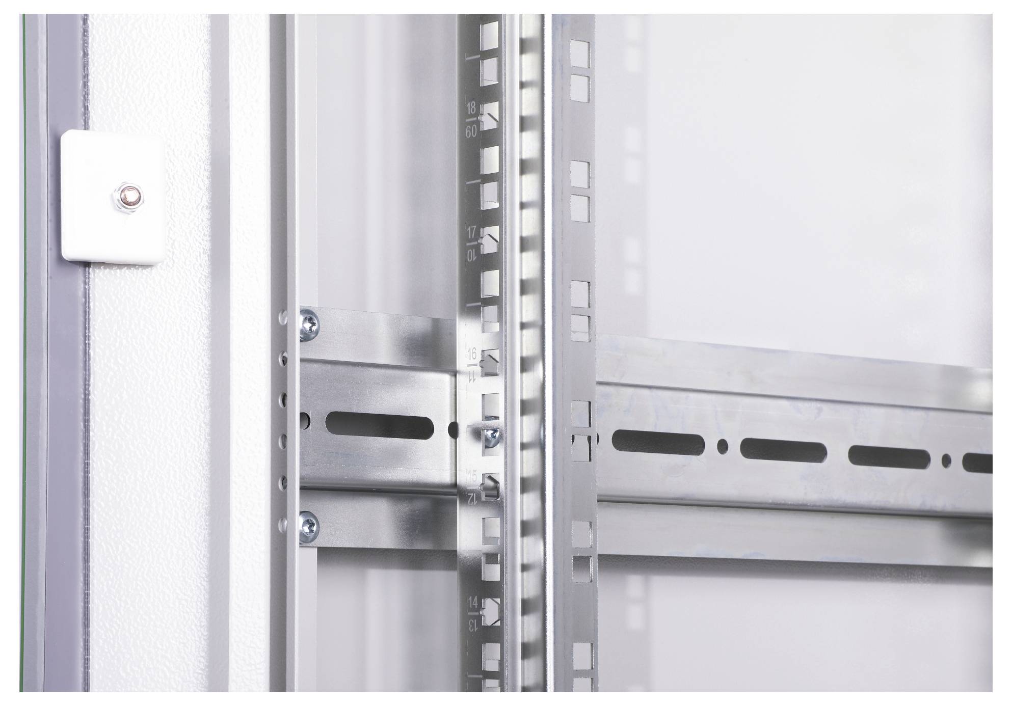 Detailaufnahme eines Schienensystems an einer weißen Wand, das Metallregale unterstützt. Deutliche Schrauben und Halterungen sichtbar.