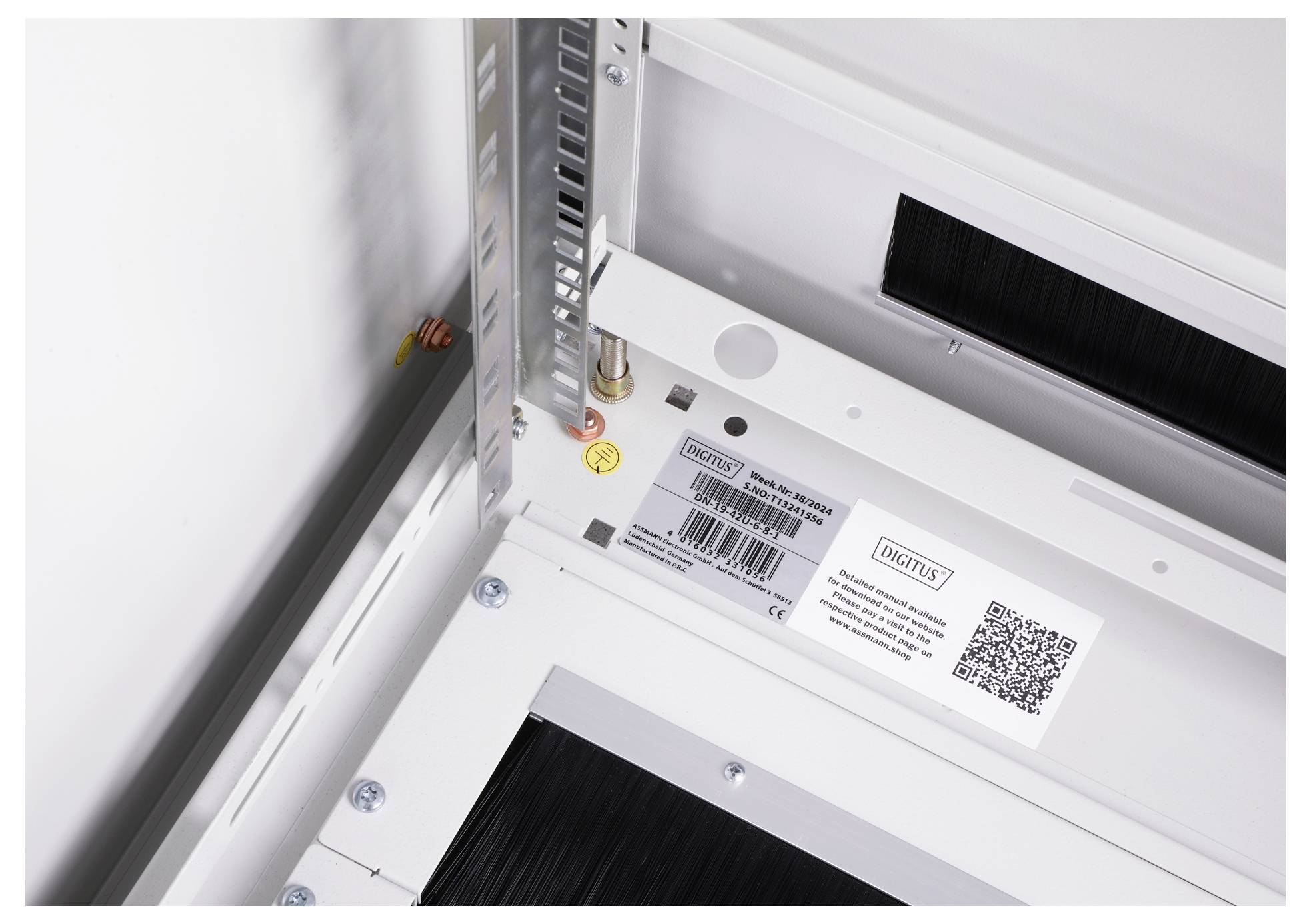 Metallstruktur mit QR-Code-Aufkleber und Schraube. Rechteckiger Raum zeigt technische Details. Der Fokus liegt auf der Beschriftung.