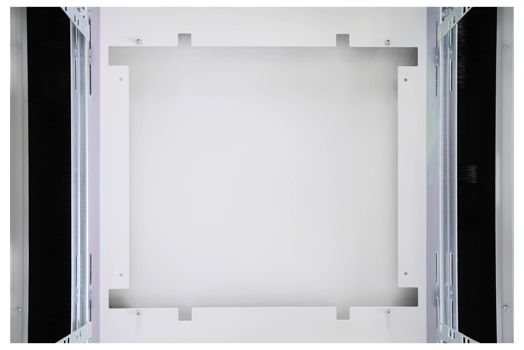 Leerer Innenraum eines Technikschranks mit weißen Wänden und Metallverstärkungen an den Seiten, geeignet für Gerätemontage.