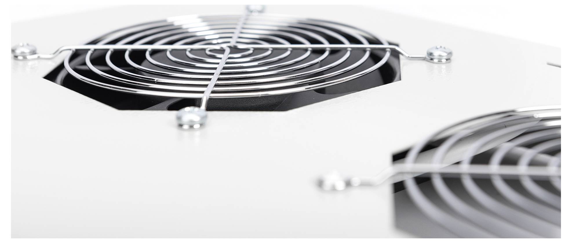 Nahaufnahme eines weißen Metallpanels mit zwei kreisförmigen Lüftungsgittern und Schrauben, was auf einen Teil eines elektronischen Geräts oder einer Haushaltsgeräte hindeutet.