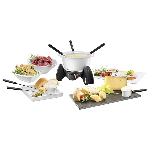 Fondue-Set mit drei Gabeln, umgeben von Fleisch, Brot, Käse und Trauben auf Platten. Ideal für gemeinsames Essen.