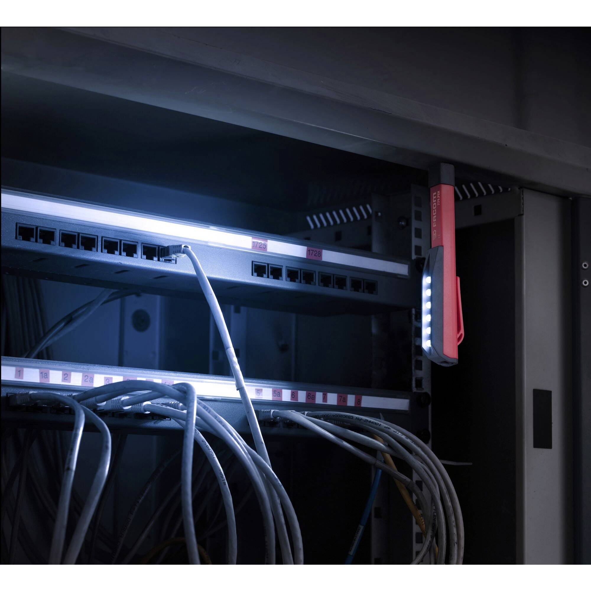 Ein beleuchteter Serverschrank mit Netzwerkkabeln und einem angebrachten Prüflicht.