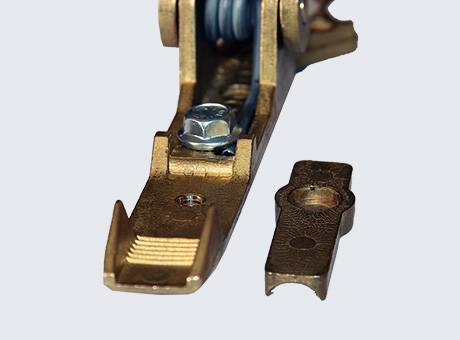 Ein Nähmaschinen-Pressfuß und sein abnehmbares Teil auf hellem Hintergrund. Der Fuß ist metallisch mit einer Schraube, positioniert neben seinem Teil.