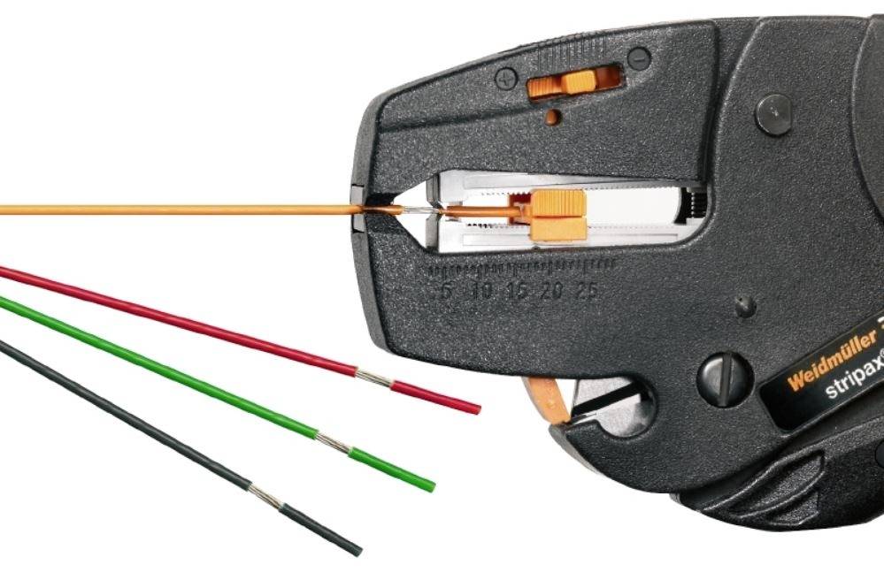 Abisolierzange entmantelt rote, grüne und schwarze Kabel, zeigt präzisen Kabelentmantelungsprozess für elektrische Anwendungen.