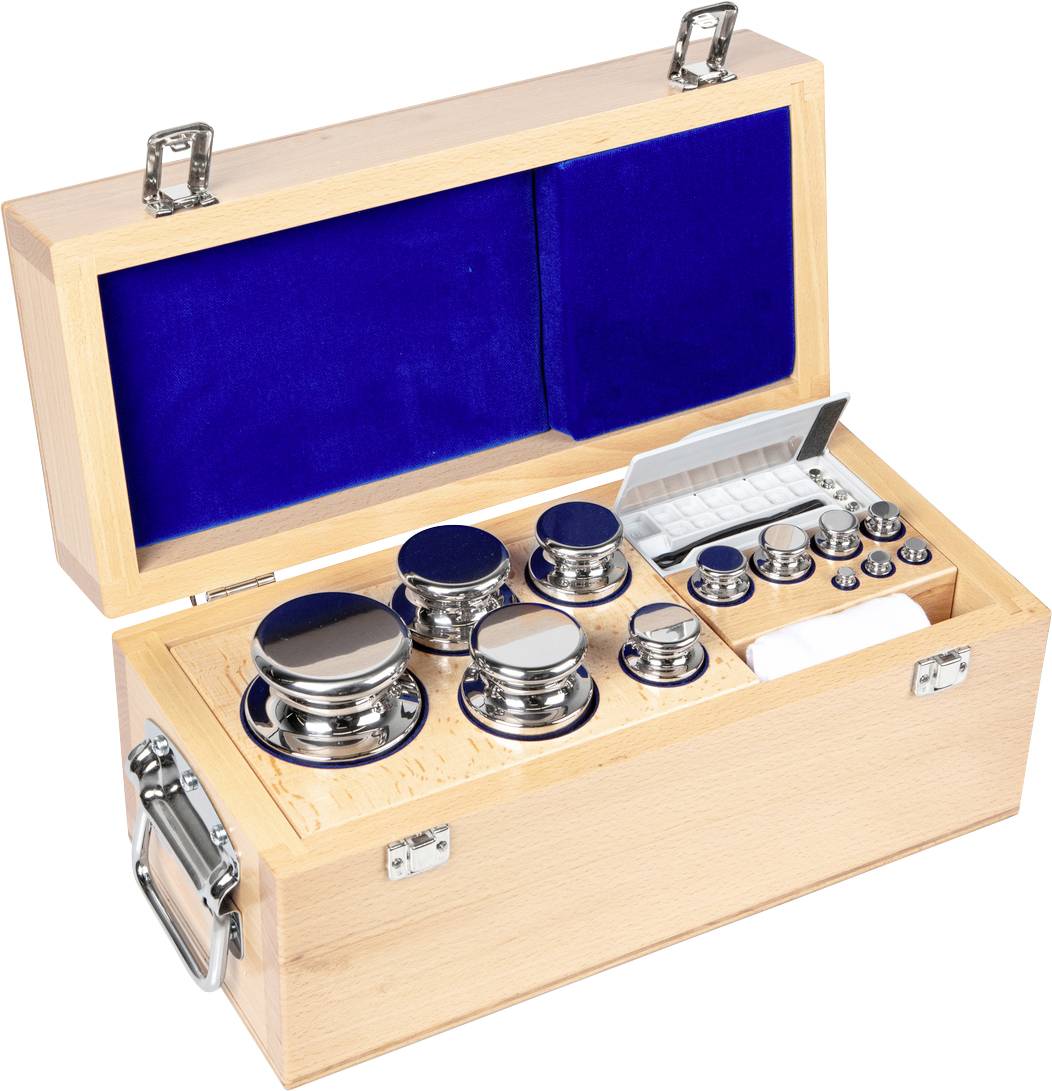 Ein offener Holzkasten mit Kalibriergewichten, die in blauer Auskleidung liegen. Verschiedene Gewichtsklassen aus glänzendem Metall sind sichtbar.