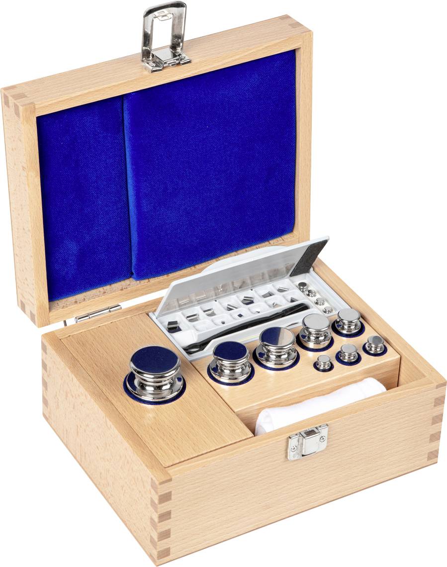 Holzkiste mit offenem Deckel, zeigt ein Set aus Gewichten und einer Waage. Enthält Metallgewichte verschiedener Größen und ein Tablett.