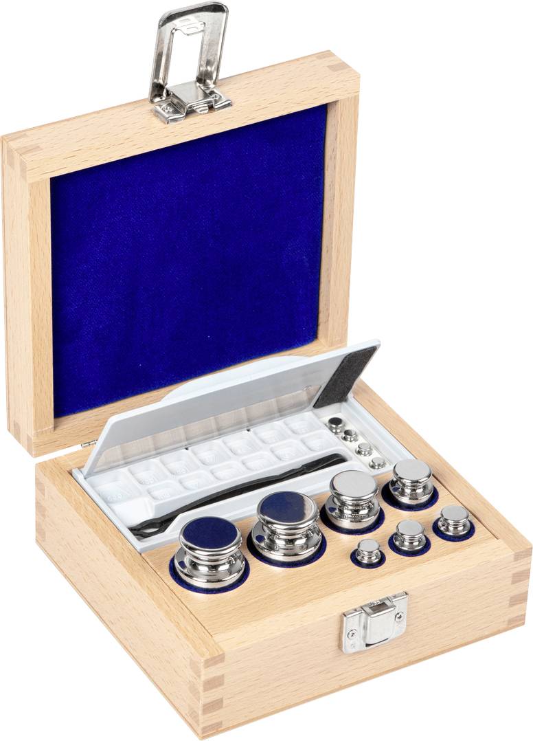 Holzkasten mit geöffnetem Deckel zeigt ein Set von Metallgewichten unterschiedlicher Größe, auf blauem Samt gebettet.
