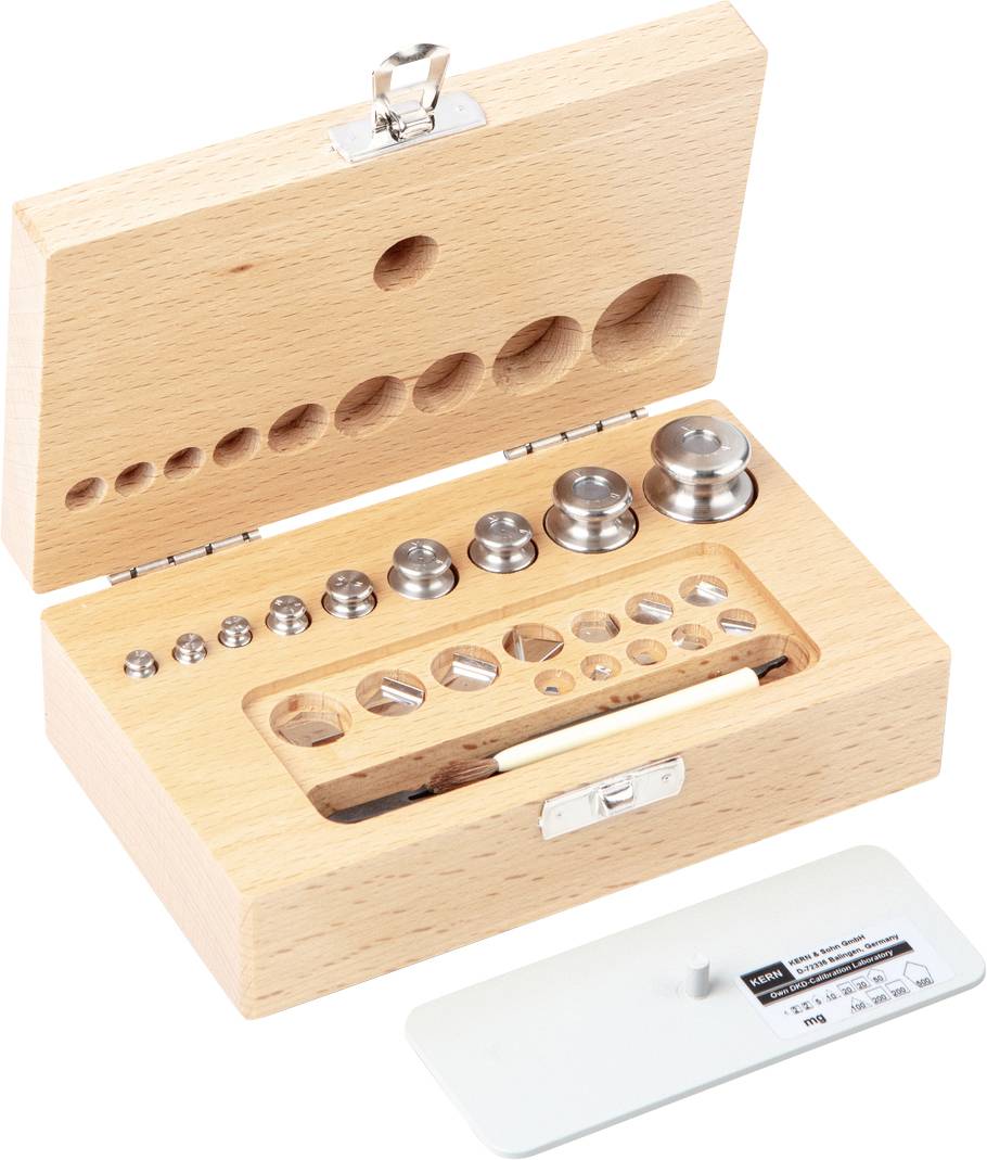 Ein Holzkasten mit kreisförmigen Gewichten in verschiedenen Größen und einem Pinzette, zur feinen Anpassung oder Kalibrierung.