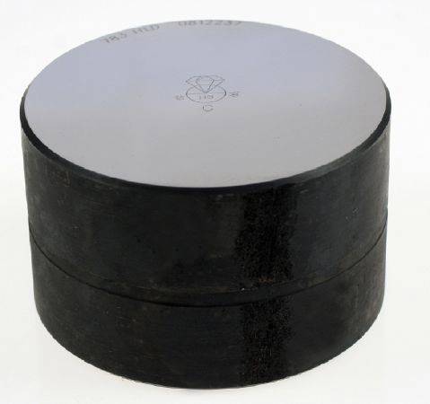 Ein kreisförmiger Silizium-Wafer, glatt und grau, auf einem dunklen, zylindrischen Sockel platziert.