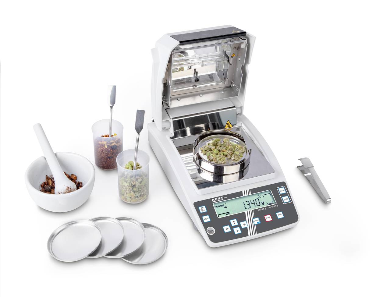 Analysewaage mit digitalem Display zeigt 134,0 an. Umgeben von Proben, einem Mörser mit Stößel, drei Probenschalen und einem Digitalmessschieber.