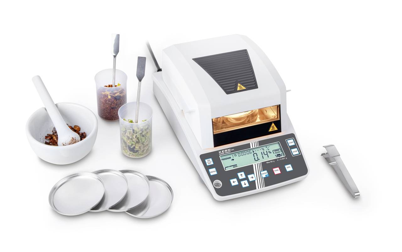 Ein Feuchtigkeitsanalysator zeigt 14% Feuchtigkeit an, umgeben von Proben in Bechern und Schalen, daneben stehen ein Löffel und Pinzetten.