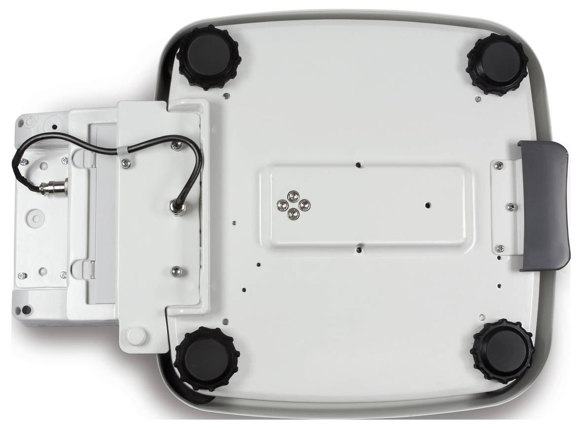 Unterseite einer elektronischen Gerätebasis mit vier gummierten Standfüßen und einem Fach für Kabelanschlüsse auf der linken Seite.