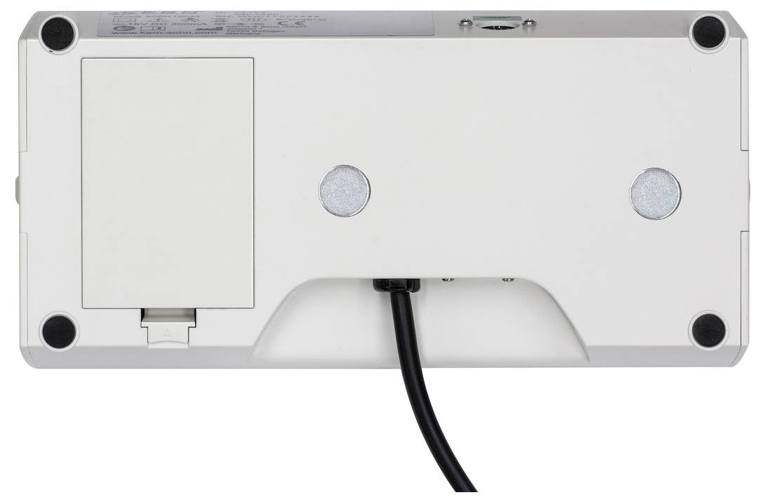 Unterseite eines elektronischen Geräts mit Schnittstellenabdeckung, zwei Öffnungen und einem herausführenden Kabel.