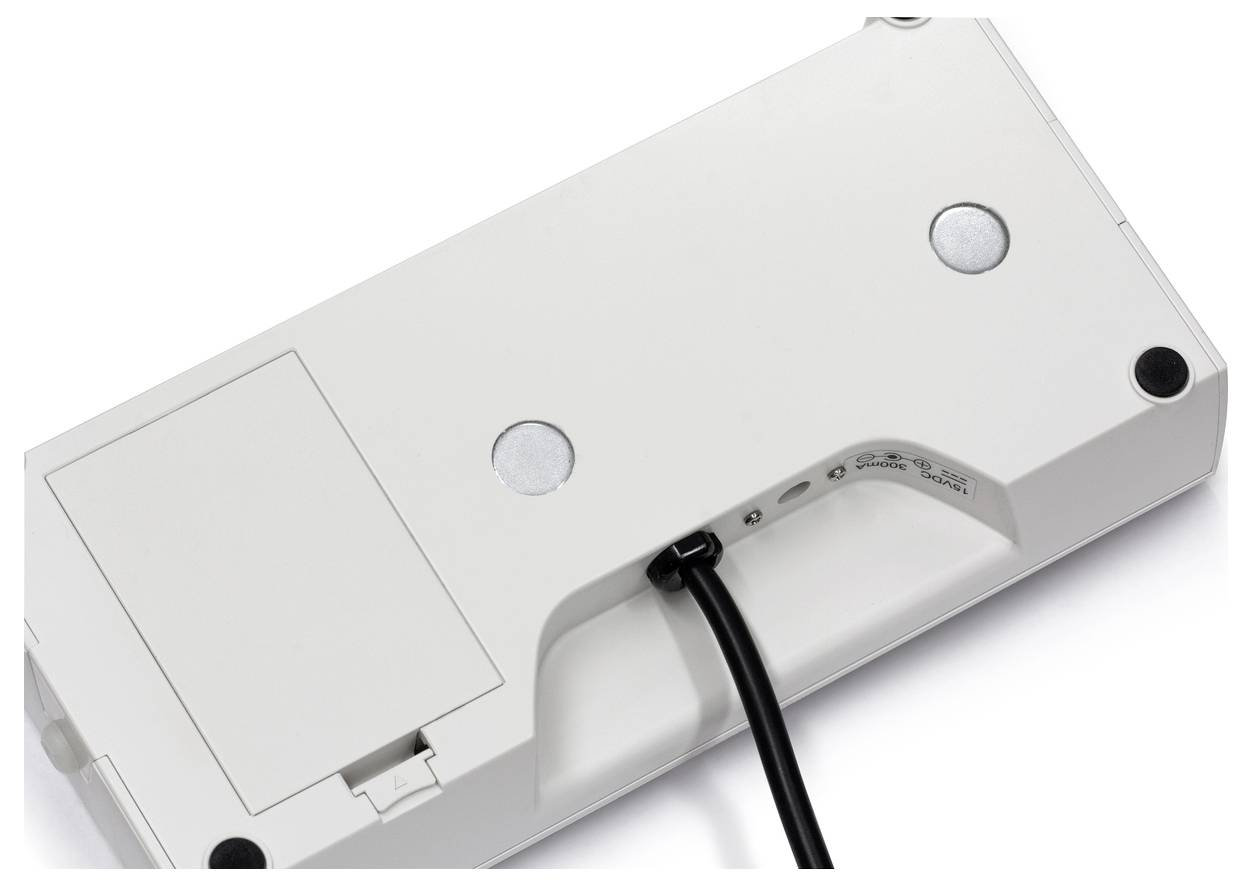 Unterseite einer weißen Computer-Tastatur mit Kabelanschluss und runden Gummifüßen an den Ecken, ohne sichtbare Tasten.