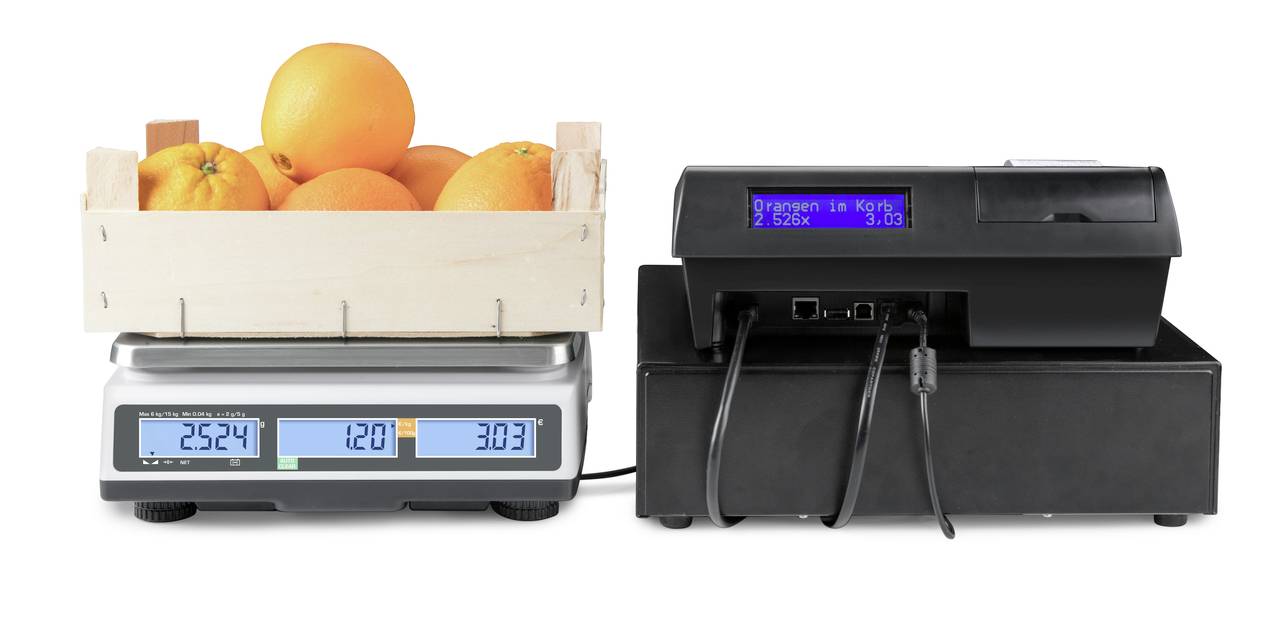 Eine Waage mit einem Korb voller Orangen zeigt '2524 g - 12,0 EUR - 3,03 EUR' an. Ein verbundenes Display zeigt 'Orangen - 12 CHF'.