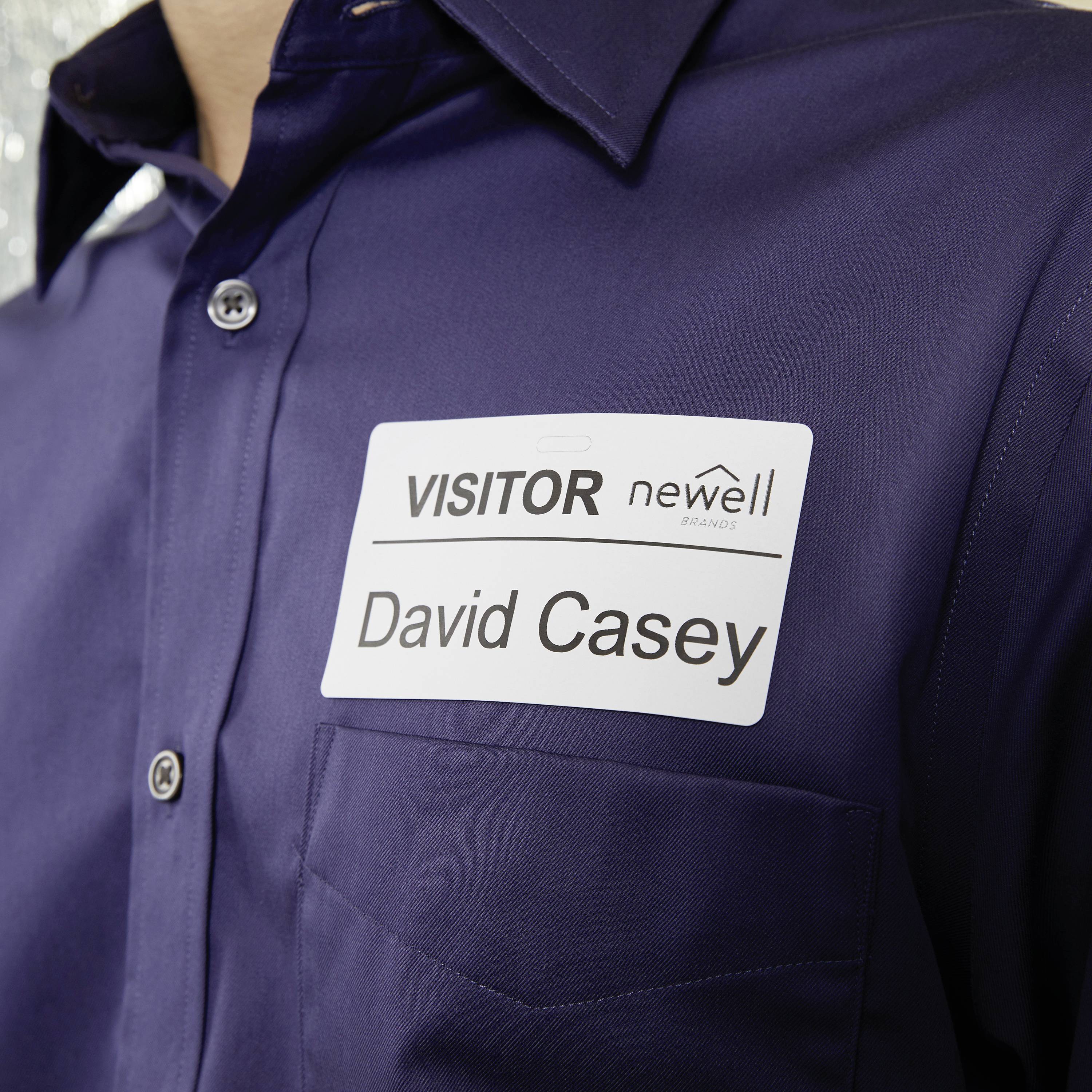 Ein Mann trägt ein Namensschild auf seiner Brust mit der Aufschrift 'VISITOR David Casey'.