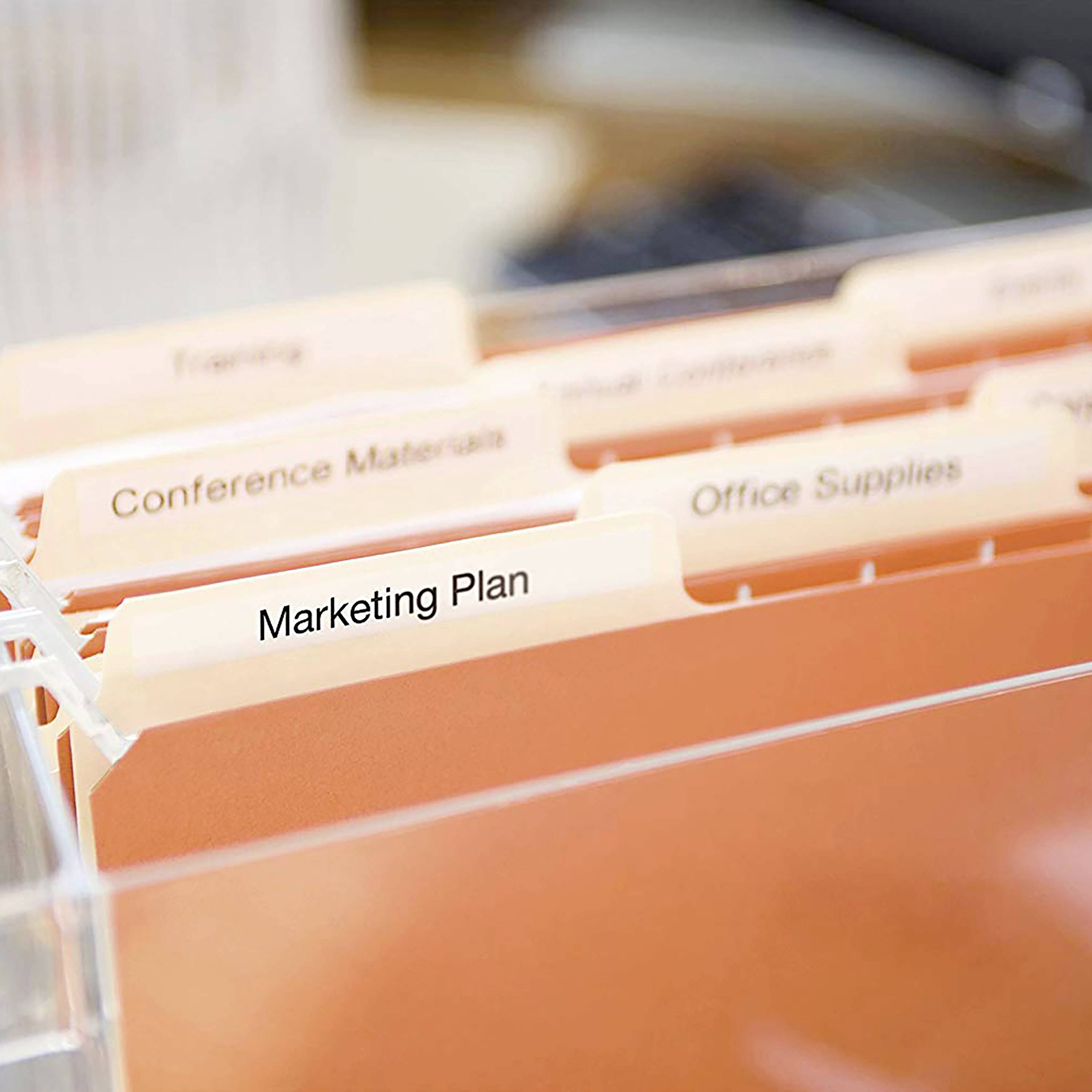 Ordnungsmappe mit Registerkarten in einem Ablagekorb. Eine hervorgehobene Registerkarte trägt die Aufschrift 'Marketing Plan'.