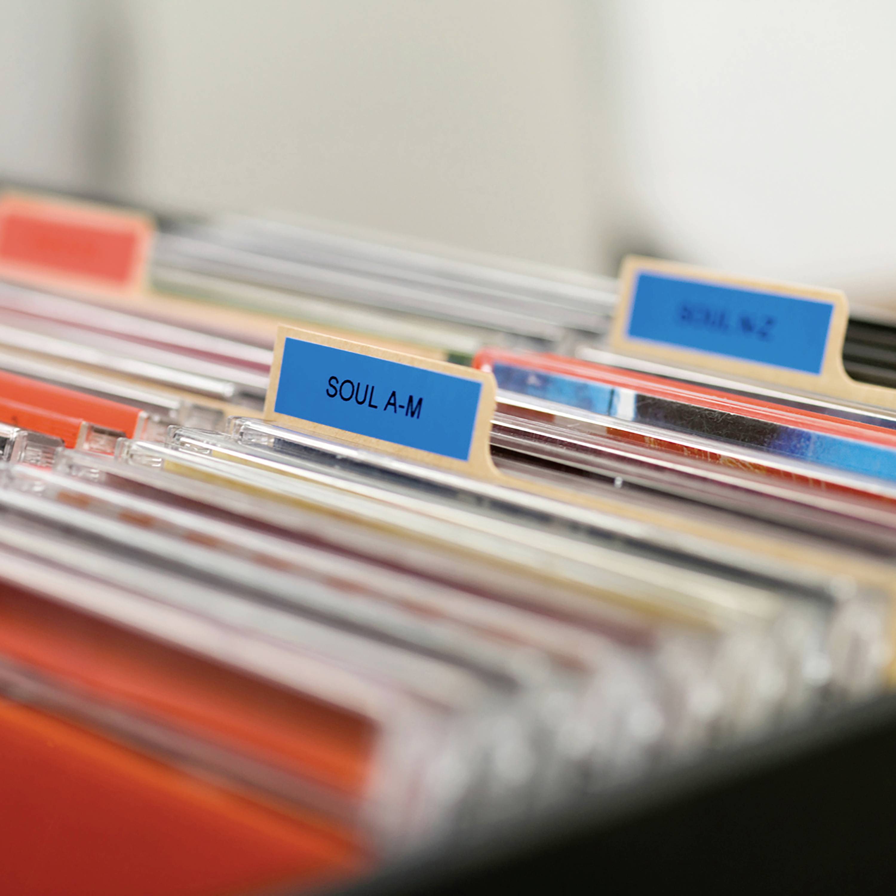 Ein geöffneter Aktenschrank zeigt Registerkarten, die alphabetisch unterteilt sind. Die Registerkarten sind blau mit schwarzer Schrift.