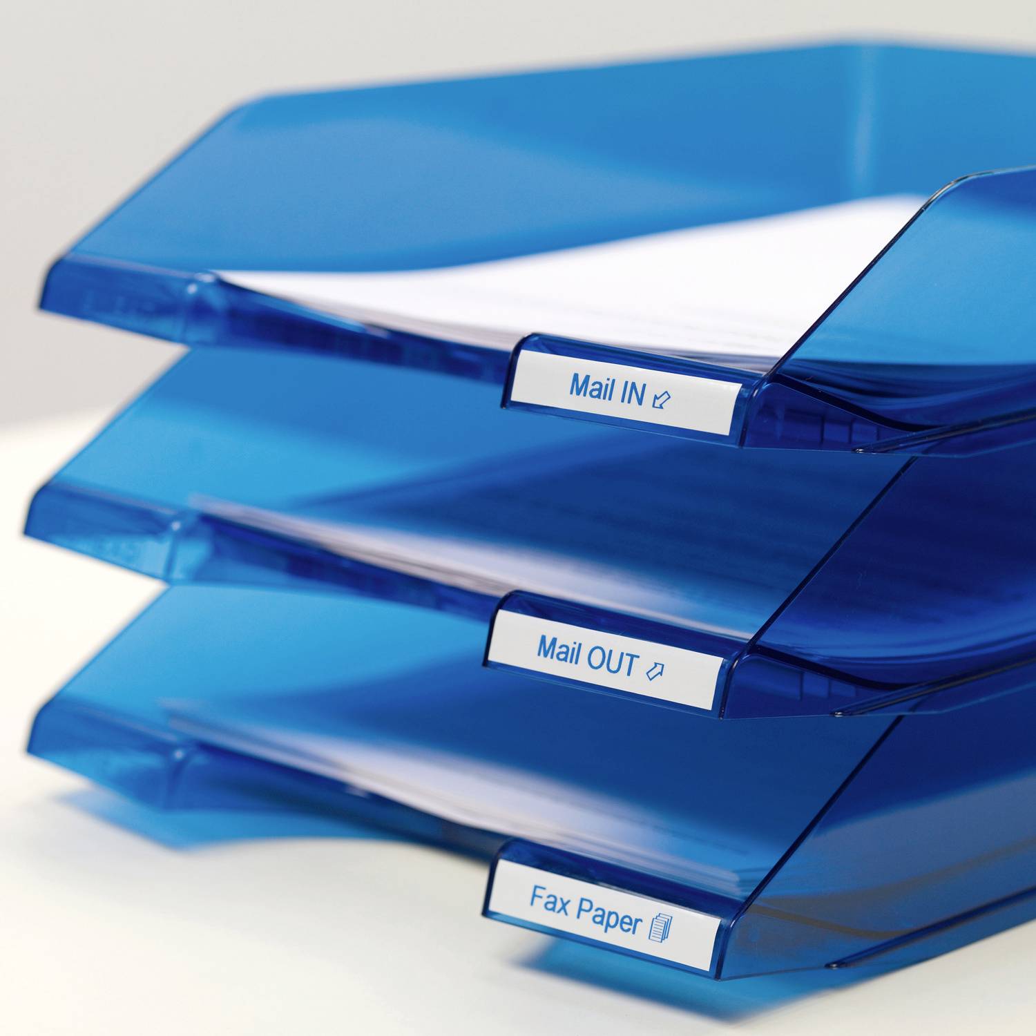 Drei blaue Ablagen mit Papieren, die mit 'Mail IN', 'Mail OUT' und 'Fax Paper' beschriftet sind, gestapelt übereinander.