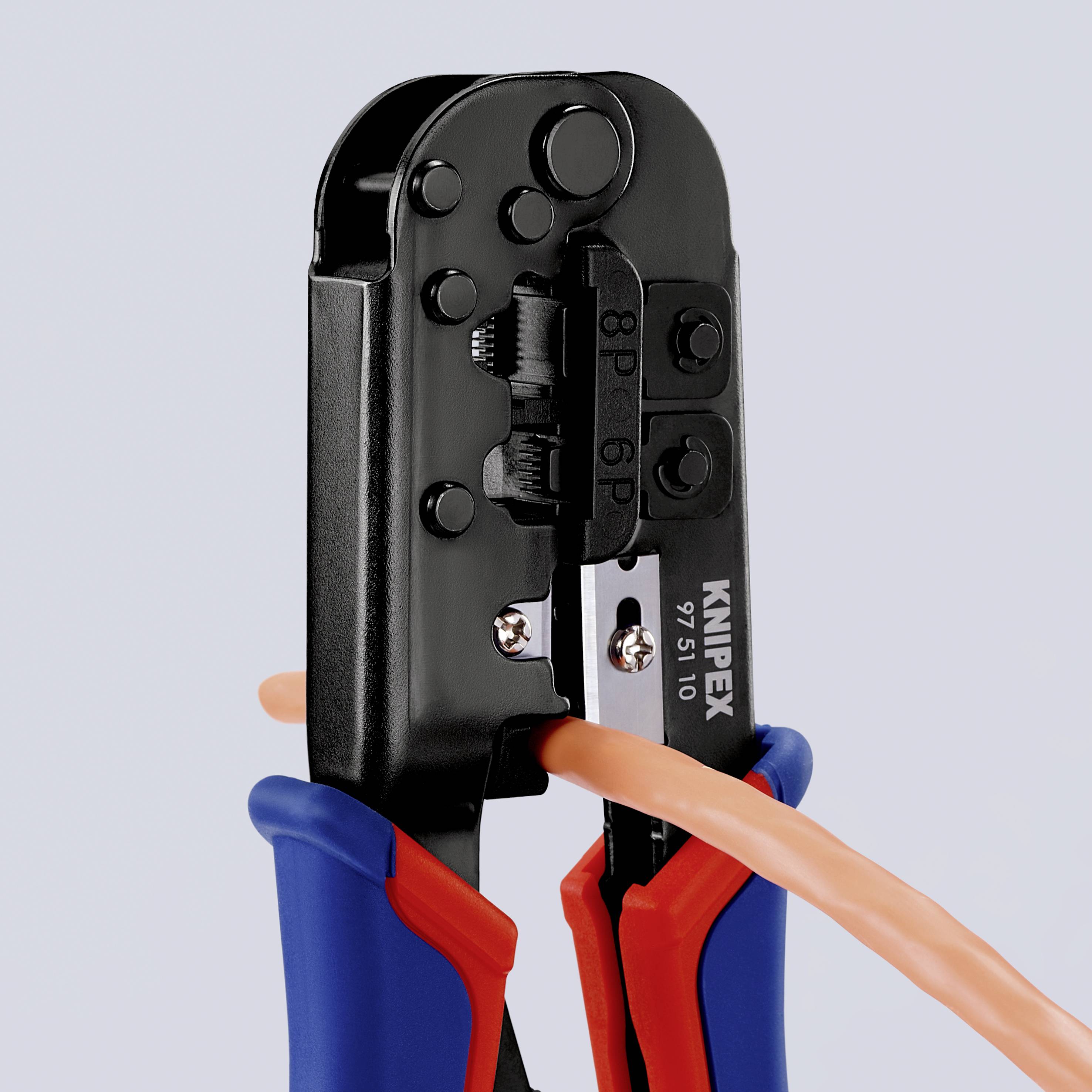Eine Knipex Crimpzange schneidet ein orangefarbenes Kabel. Die Zange hat blaue und rote Griffe und wird zum präzisen Arbeiten eingesetzt.