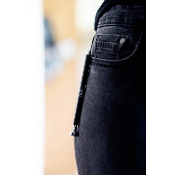 Eine schwarze Jeans mit einem Stift, der in der Hosentasche steckt. Der Fokus liegt auf dem Stift.